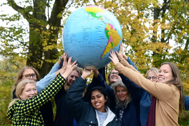 People holding the earth (miniature). Photo